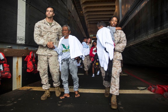 U.S. Marines with the 15th Marine Expeditionary Unit assist distressed mariners ready to be transported to an Indonesian coast guard vessel from the USS Rushmore (LSD 47), June 11, 2015. The distressed mariners were rescued from a sinking craft in the Makassar Strait. Once on board, the mariners were provided food and medical attention by Marines and Sailors of the 15th MEU and Essex Amphibious Ready Group. (U.S. Marine Corps photo by Sgt. Emmanuel Ramos/Released)